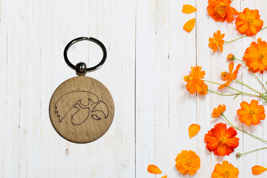 Wooden keychain with engraved design of a tiger hawk. 