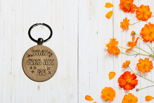 Keychain with engraved text "That curb hit me"
